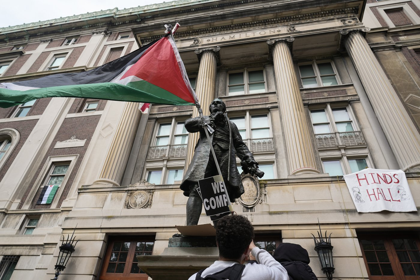 A student protester parades a Palestinian flag outside the entrance to Hamilton Hall on the campus of Columbia University, Tuesday, April 30, 2024, in New York.